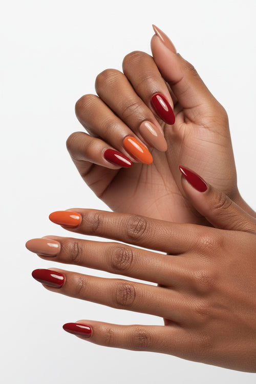 A clean product close-up of the Autumn Spice Set by Bloom Gloss Co, showcasing fifteen glossy almond fake nails arranged in rows of vibrant pumpkin orange, warm caramel nude, and rich brick red.